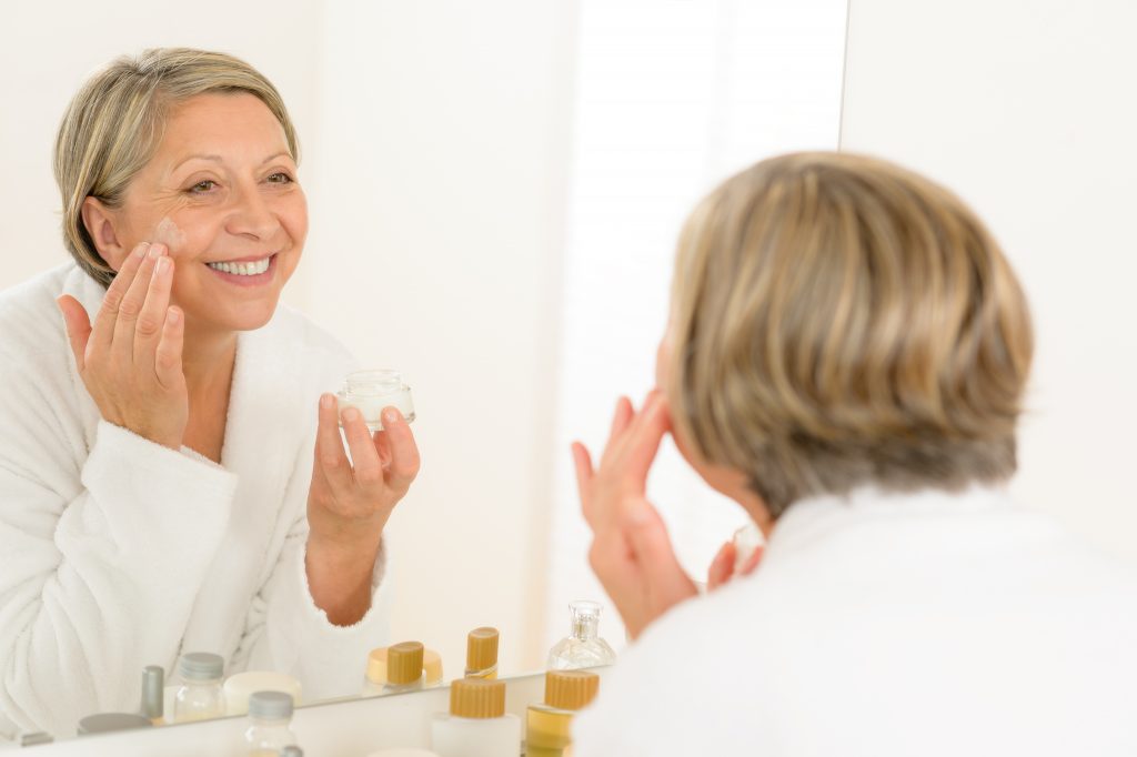 middle-aged woman applying firming lotion