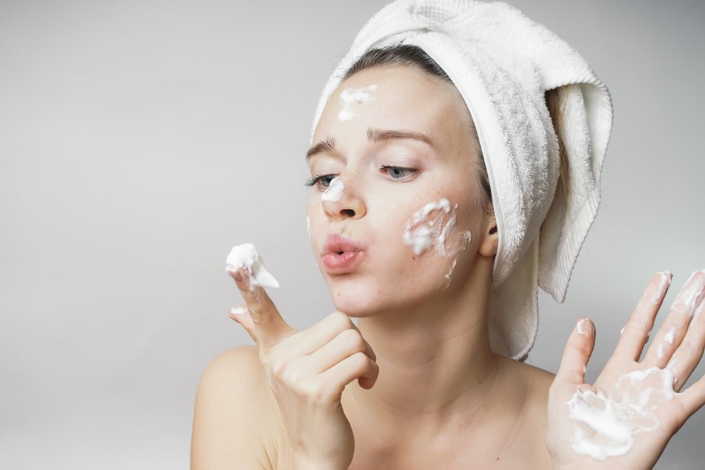 woman applying cream on her face