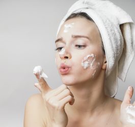 woman applying cream on her face